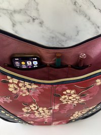 Curved semi-slouchy handbag with matching eyewear/sunglass case, in a floral pattern in cream, pink, and maroon tones, with a rich solid navy