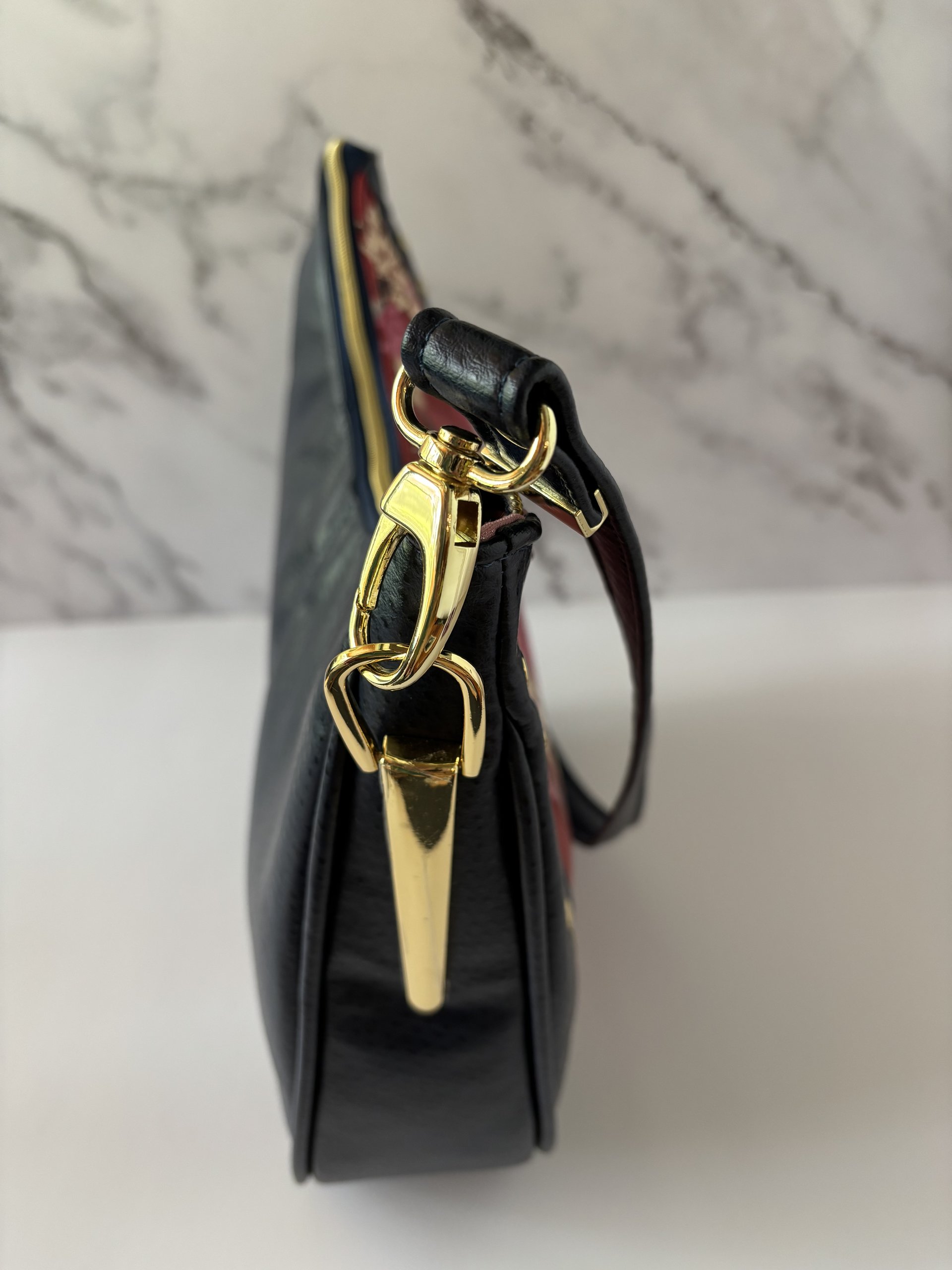 Curved semi-slouchy handbag with matching eyewear/sunglass case, in a floral pattern in cream, pink, and maroon tones, with a rich solid navy